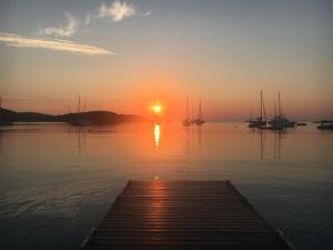a sunset over a dock with boats in the water at Hotel Les Chambres de Mila Bonifacio in Bonifacio