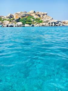 a large body of water with an island in the background at Hotel Les Chambres de Mila Bonifacio in Bonifacio