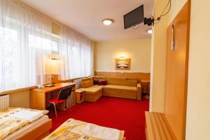 a hotel room with a bed and a couch at Dom Sportowca Błonie - MOSiR in Sanok