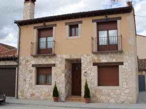 una casa con 2 balcones en la parte delantera en CASA RURAL LA FINCA DEL POZO en Segovia