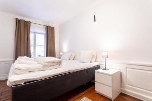 a white bedroom with a large bed with a window at ApartDirect Gamla Stan in Stockholm