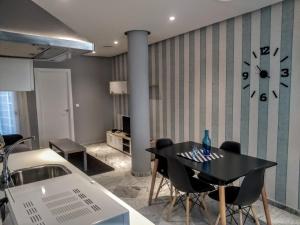 jadalnia ze stołem i zegarem na ścianie w obiekcie Apartamentos El Vestuario w Kadyksie +12 zdjęć