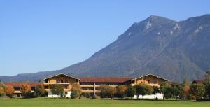 a large building with mountains in the background at Chiemgau Appartements in Inzell