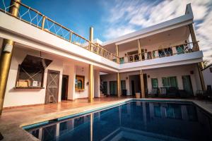 a house with a swimming pool and a balcony at Hotel Boutique Skulls Landing in Isla Mujeres