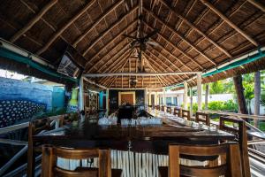 a dining room with a long table and chairs at Hotel Boutique Skulls Landing in Isla Mujeres