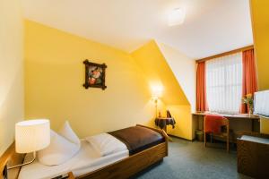 um quarto de hotel com uma cama e uma janela em Hotel Achtermann em Braunlage