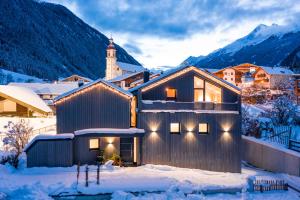 een huis in de sneeuw met een berg bij Ferienhaus zum Stubaier Gletscher - Dorf in Neustift im Stubaital