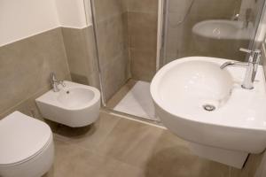 e bagno con servizi igienici, lavandino e doccia. di Garda Rooms a Desenzano del Garda