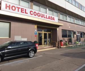 un coche negro estacionado frente a un hotel colocalia en Hotel Cogullada, en Zaragoza