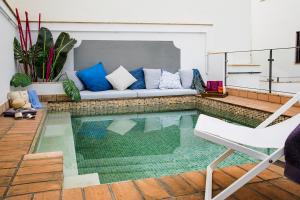 een woonkamer met een bank en een zwembad bij Matahacas Pool & Luxury in Sevilla