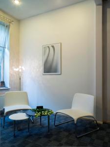 two white chairs and a table in a room at Elizabete Design Hotel in Riga