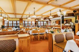 a restaurant with tables and chairs in a room at Hotel Achtermann in Braunlage