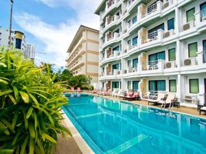 a swimming pool in front of a building at Best Beach Villa in Pattaya