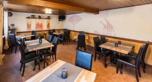 a restaurant with tables and chairs in a room at Hotel Es Lämmche in Breuberg