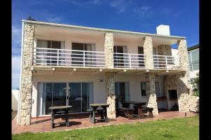 a white house with a balcony on top of it at Villa Amore in Paternoster