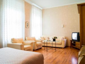 a living room with two couches and a tv at Elizabete Design Hotel in Rīga
