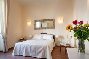 1 dormitorio con 1 cama y un jarrón de flores en Vatican Domus Smart Rooms, en Roma