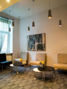 a waiting room with chairs and tables and a painting at Elizabete Design Hotel in Riga