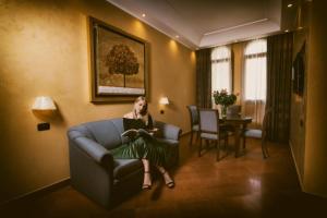 a woman sitting in a chair in a room at Artemis Hotel in Cefalù