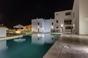 a swimming pool in front of a building at night at The Florence Hills Resort & Wellness in Pelago