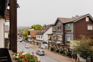 una calle de la ciudad con casas y coches en la carretera en Hotel Achtermann en Braunlage