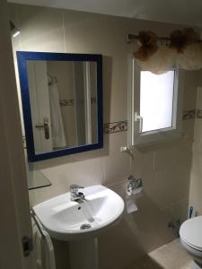 La salle de bains est pourvue d'un lavabo, d'un miroir et de toilettes. dans l'établissement Denia Playa III, à Dénia