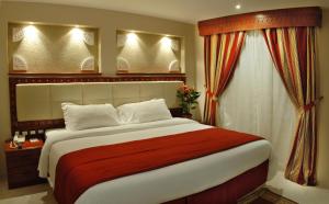 a bedroom with a large bed and a window at Al Liwan Suites in Doha