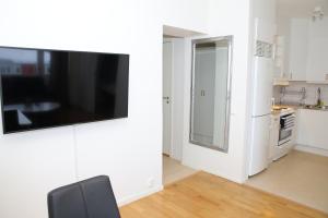 a living room with a flat screen tv on a wall at Fastliving Apartment Hotel in Västerås
