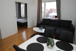 a living room with a black couch and a table at Fastliving Apartment Hotel in Västerås