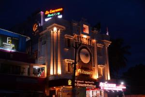 a building with neon signs on it at night at Le Emerald Residency in Tambaram