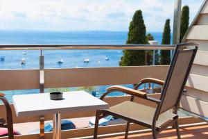 uma mesa e cadeiras numa varanda com vista para o oceano em Canyelles Platja em Roses