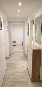 a hallway of a bathroom with a vanity and a mirror at Apartman Sevilya in Kostrena