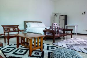 a bedroom with a bed and a table and chairs at White House Langkawi in Kuah