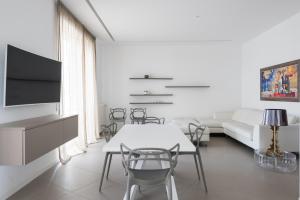 un soggiorno bianco con tavolo e sedie bianchi di Design e Comfort nel centro di Catania by Wonderful Italy a Catania