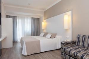 a hotel room with a bed and a couch at Canyelles Platja in Roses