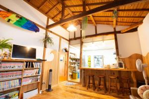 a living room with a bar and bookshelves at Tabist Guest house Pumping Surf in Hyuga