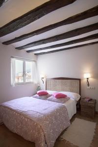um quarto com uma cama grande e almofadas cor-de-rosa em Altalea em Pamplona
