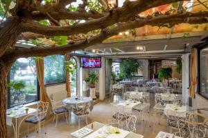 a restaurant with tables and chairs under a tree at Orto Di Roma in Rome