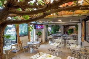 un restaurante con mesas y sillas bajo un árbol en Orto Di Roma en Roma