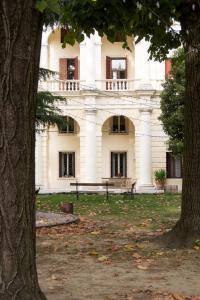 un grande edificio bianco con una panchina di fronte di Guest House Villa Angaran San Giuseppe a Bassano del Grappa