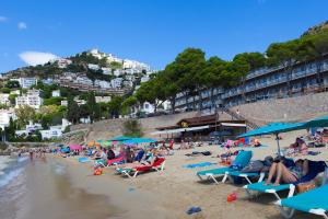a group of people sitting on a beach at Canyelles Platja in Roses