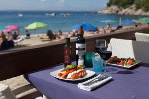 una mesa con un plato de comida y vino en la playa en Canyelles Platja en Rosas