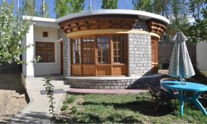 a small circular house with a table and an umbrella at Royal Heritage Resort in Leh