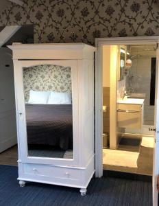 a bedroom with a bed and a bathroom with a sink at B&B Coupure in Bruges