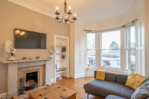 a living room with a couch and a fireplace at Edinburgh Serviced Apartment in Edinburgh