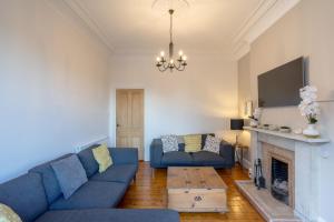 a living room with a blue couch and a fireplace at Edinburgh Serviced Apartment in Edinburgh