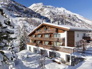 un chalet dans la neige dans les montagnes dans l'établissement Hotel Plateau Rosa, à Zermatt