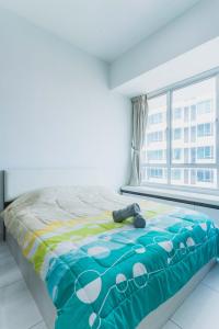 a bed in a room with a large window at Shawn Akademic Suites Pool View @ Mount Austin in Johor Bahru