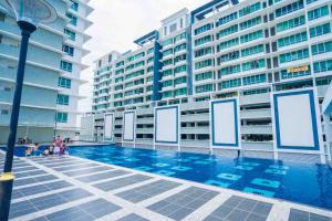 une piscine en face de certains grands bâtiments dans l'établissement Shawn Akademic Suites Pool View @ Mount Austin, à Johor Bahru