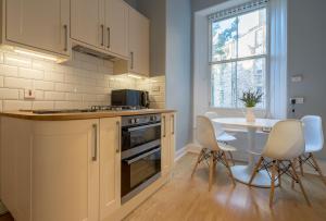 uma cozinha e sala de jantar com mesa e cadeiras em Edinburgh Serviced Apartment em Edimburgo